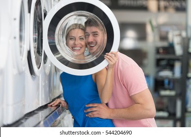 Beautiful Young Couple Shopping For Washing Machine In Produce Department Of A Grocery Store - Supermarket - Shallow Deep Of Field