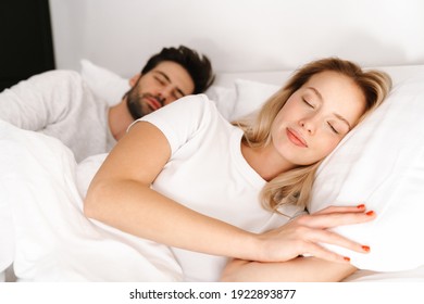 Beautiful young couple sleeping in bed together