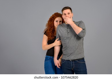 A beautiful young couple standing and feeling scared in a studio