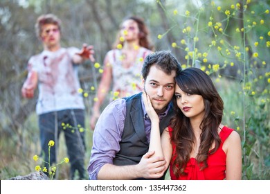 Beautiful Young Couple taking a portrait with Zombies approaching