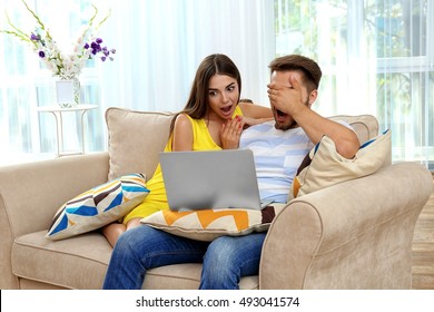 Beautiful young couple using laptop at home - Shutterstock ID 493041574