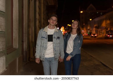 Beautiful Young Couple Walking On The Street. Young Couple On An Evening Romantic Date. Night City On The Background.