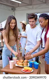 Beautiful Young Diverse Friends People Eating Burgers Sandwich On Backyard Terrace Of House, Gathered Together At Summer Evening, Spending Weekends With Friends. Unity, Youth, Friendship Concept