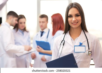 Beautiful young doctor with team in conference room