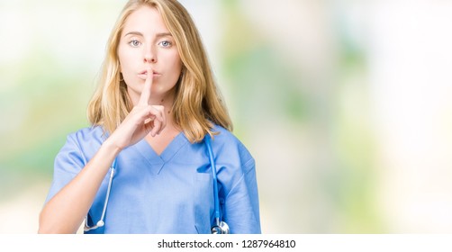 Beautiful young doctor woman wearing medical uniform over isolated background asking to be quiet with finger on lips. Silence and secret concept.