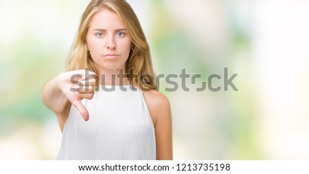 Beautiful young elegant woman over isolated background looking unhappy and angry showing rejection and negative with thumbs down gesture. Bad expression.