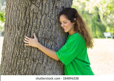 Beautiful Young Environmentalist Embracing Tree Trunk In Park