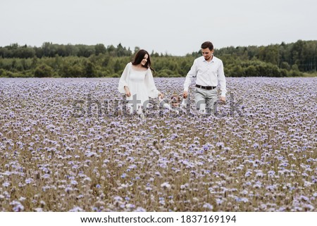 Beautiful young family with a boy resting in a field of flowers.
