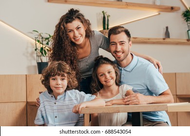 Beautiful Young Family In Cafe With Modern Trendy Interior