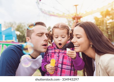 Beautiful young family enjoying their time at fun fair