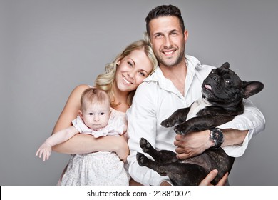 Beautiful Young Family With Little Baby And Dog Isolated Over Grey Background