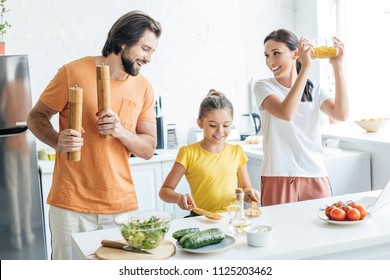 Beautiful Young Family Playing Music With Kitchenware And Having Fun At Kitchen