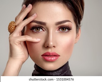 Beautiful young fashion woman with living coral lipstick. Attractive white girl wears luxury jewelry.  Glamour fashion model with bright gloss make-up posing at studio. Stylish fashionable concept.