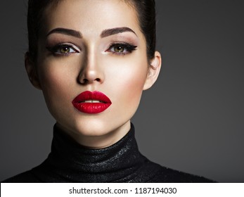 Beautiful young fashion woman with red lipstick. Glamour fashion model with bright gloss make-up  posing at studio.