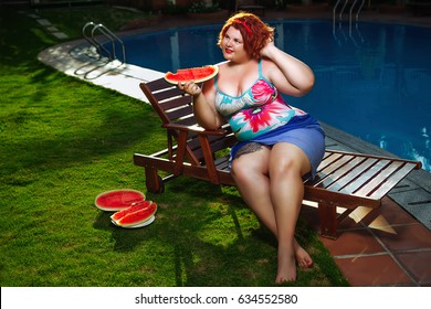 Beautiful young fat woman relaxing on deck chair by the pool