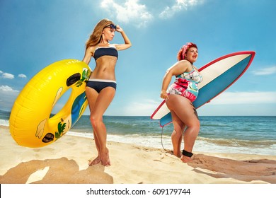 Beautiful young fat woman is runing to the summer sea with the surfboard