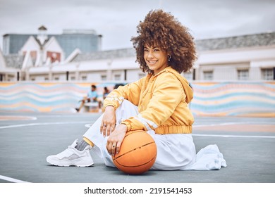 Beautiful, Young And Female Basketball Coach With Sitting On The Court Outside. Portrait Of A Professional, Confident And Healthy Athlete Woman In Sports, Health And Fitness.