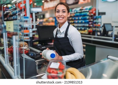 Beautiful young female cashier working at a grocery store. - Powered by Shutterstock