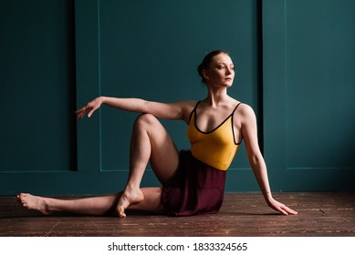 Beautiful Young Female Classical Ballet Dancer On Pointe Shoes Wearing Leotard And Skirt On A Studio Background