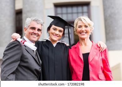 Beautiful Young Female Graduate With Parents At Ceremony