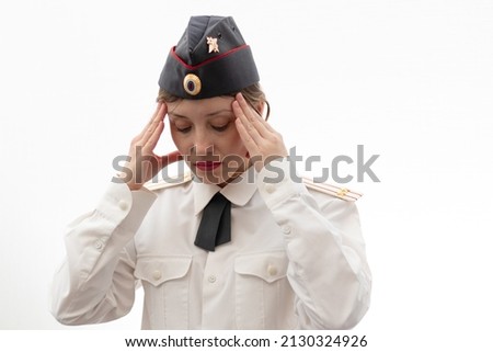 A beautiful young female Russian police officer in dress uniform in a cap and shoulder straps of a lieutenant colonel and a white shirt on a white background. Selective focus. Portrait