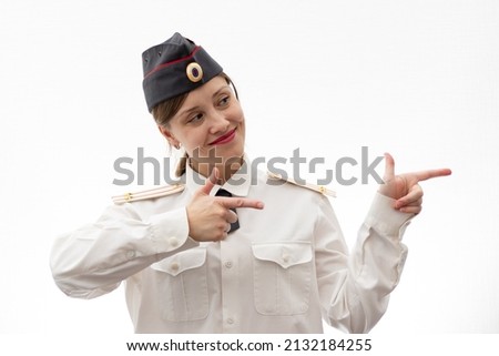 Beautiful young female Russian police officer in dress uniform shows signs with her hands on a white background. Selective focus. Portrait