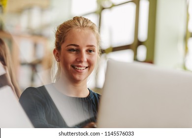 Beautiful Young Female Student Using Laptop In Classroom. Girl Studying With Laptop In University Class.