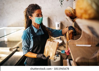 Beautiful young female worker with protective mask on face working in bakery. - Powered by Shutterstock