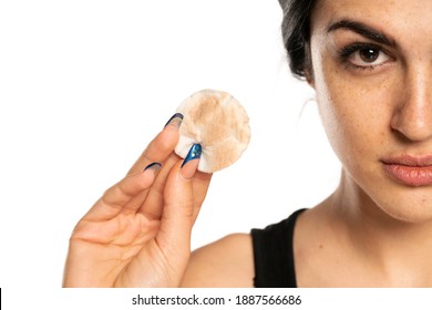 Beautiful Young Freckled Woman Showing A Dirty Cotton Pad On A White Background