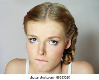 The beautiful young girl with blue sad eyes thinks, close-up