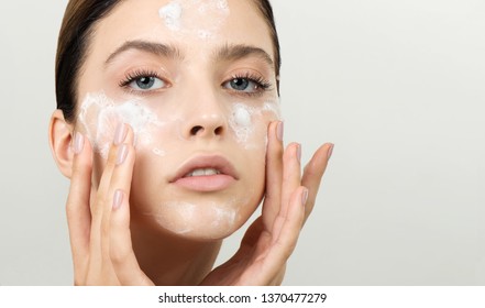 Beautiful young girl cleansing face with cosmetic facial skincare foam, gel or soap. Woman hame SPA procedures. - Shutterstock ID 1370477279
