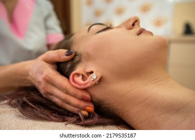 Beautiful Young Girl With Dark Hair Doing A Head Massage In A Massage Parlor. Head Massage Concept