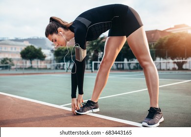 Beautiful Young Girl Doing Stretching Workout Outdoors. Sportswoman Doing Warmup Exercise On Tennis Court.