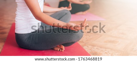 Beautiful young girl doing yoga on the mat, relaxes, taking care of health.