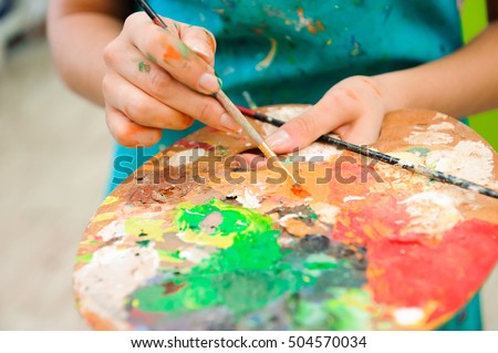 beautiful young girl draws a picture paints on art lesson