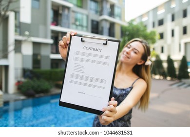 beautiful young girl extends contract, focus on document. concept of offices for delivery of housing, real estate real estate long-term or short-term lease. Front used with Open Font License