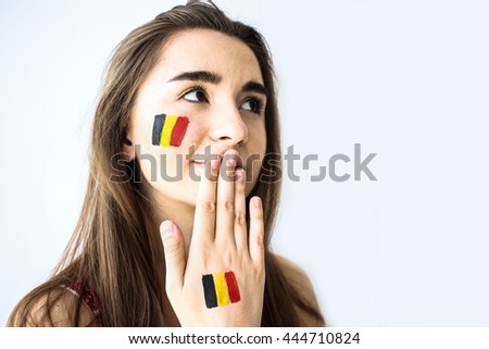 Beautiful young girl football fan with belgian flag on face closeup