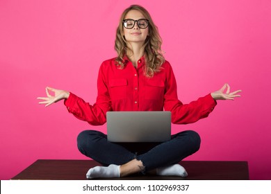 Beautiful Young Girl With Glasses Sitting In A Red Shirt Near A Laptop On A Red Background