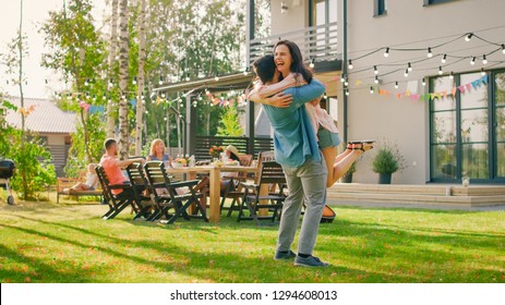 Beautiful Young Girl Hugs Her Boyfriend. Two Young People Embrace in the Backyard of a Garden on a Hot Summer Day.