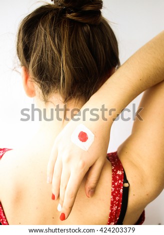 Beautiful young girl with japan flag hand & manicure, from behind