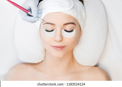 Beautiful Young Girl With Long Eyelashes Tweezing Her Eyebrows In A Beauty Salon. Eyebrow Correction. Beauty Concept. Permanent Makeup. Microblading Brow. Beautician Doing Brows Tattooing. Treatment.