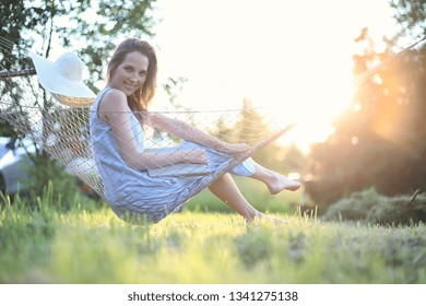 Beautiful young girl lying and reading a book in the summer outdoors