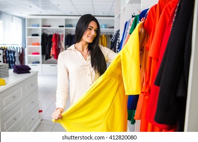 Beautiful Young Girl Measures The Dress In The Shop.girl On A Shopping