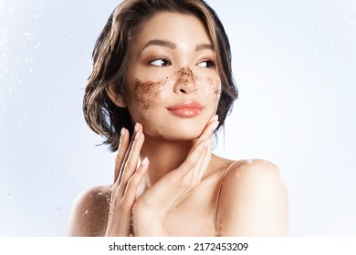 Beautiful Young Girl With Naked Shoulders Scrubbing Face, Pretty Female Cleansing Facial Skin By Natural Organic Scrub During Taking A Shower. Skincare Daily Routine, Selfcare, Woman Beauty Concept.