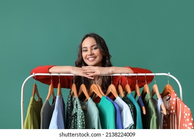 Beautiful Young Girl Near Rack With Clothes For High School Prom On Green Background