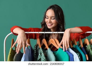 Beautiful Young Girl Near Rack With Clothes For High School Prom On Green Background