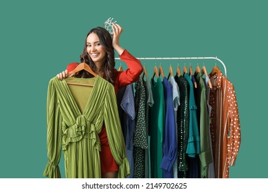 Beautiful Young Girl Near Rack With Clothes For High School Prom On Green Background