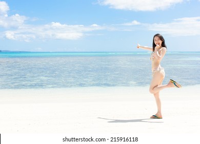 beautiful young girl pointing to the sea on tropical island beach 