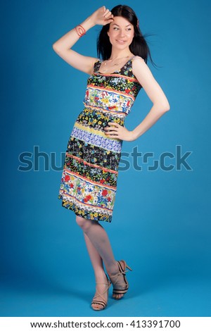 Beautiful young girl posing in street clothes on blue background.Isolated studio portrait