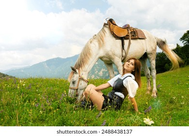 Beautiful young girl sitting next to her white horse at sunset in the mountains on the flower field - Powered by Shutterstock